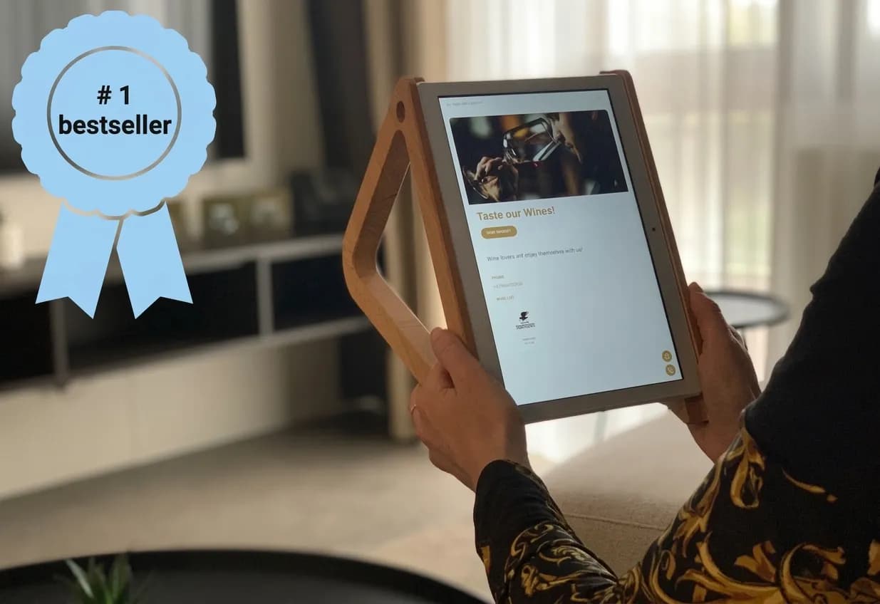 Guest holding a MyStay in-room tablet in a hotel room